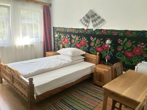 een kleine slaapkamer met een bed en een tafel bij Pensiunea Agroturistica Cristal in Suceviţa