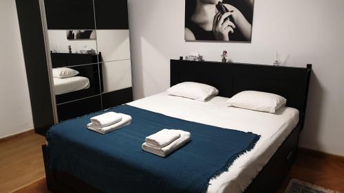 a bedroom with a bed with two towels on it at Old Town Bliss in Bucharest
