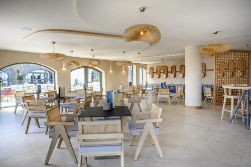 a restaurant with tables and chairs in a room at Creta Maris Resort in Hersonissos
