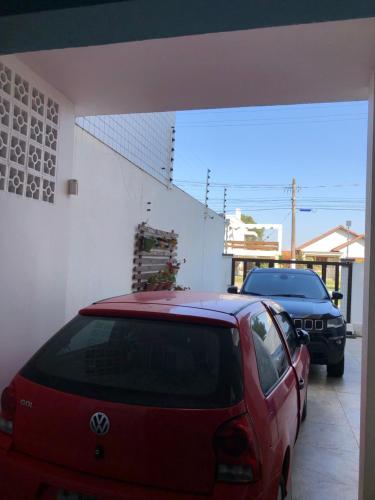 une voiture rouge garée devant un garage dans l'établissement Anexo da Cal, à Torres