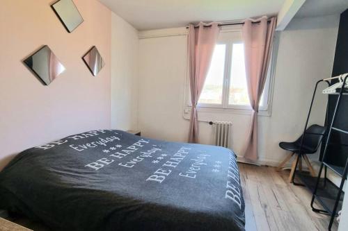 um quarto com uma cama com um cobertor preto em Chez karole proche gare direct Paris em Coulommiers