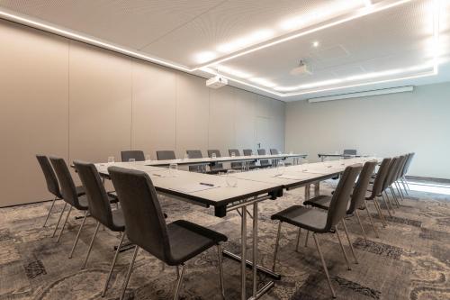 a large conference room with a long table and chairs at Novotel Duesseldorf Airport in Düsseldorf