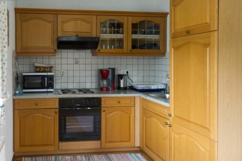 a kitchen with wooden cabinets and a stove top oven at Ganhör- Fam. Kaar in Wintersdorf