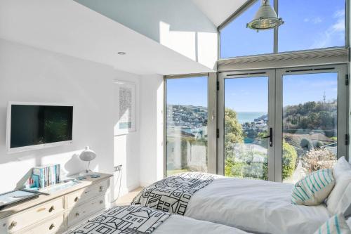 1 dormitorio con cama y ventana grande en The Looking Glass, en Dartmouth