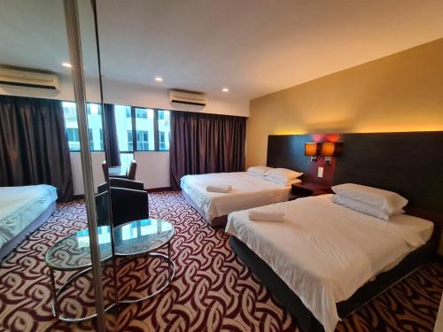 a hotel room with two beds and a table at SUN GARDEN Studio and Residences at South China Sea Place Suites in Kota Kinabalu