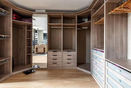 - un dressing avec des armoires et des tiroirs en bois dans l'établissement Villa avec Piscine - 15 ' JO - Vélos - 30 ' Disney, à Saint-Maur-des-Fossés