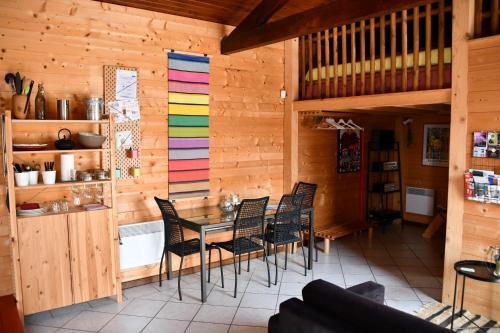 a dining room with wooden walls and a table and chairs at Gîte Etchola in Ramous