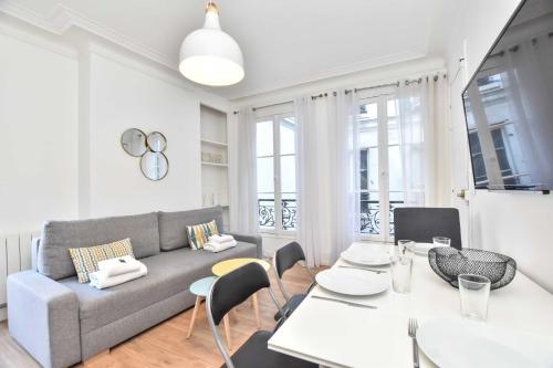 a living room with a couch and a table and chairs at Lovely flat 4 P Palais Royal - Musée du Louvre in Paris