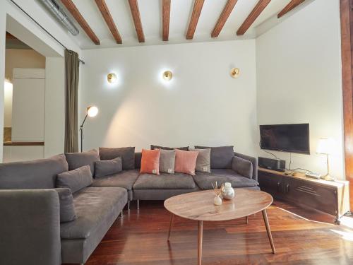 a living room with a couch and a table at Barcelonaforrent Alessandra Central Ramblas Apartment in Barcelona