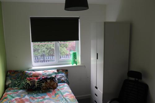 a bedroom with a window and a bed with a pillow at TULLIS Town House - Glasgow Green in Glasgow