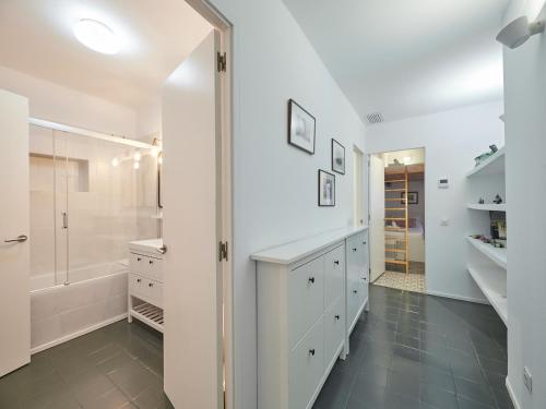 La salle de bains blanche est pourvue d'une douche et d'un dressing. dans l'établissement BarcelonaForRent Alessandra Central Ramblas, à Barcelone