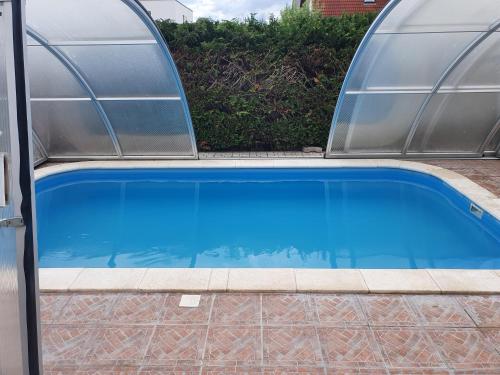 una piscina con dos cúpulas alrededor en Pihenés Háza-Relax Apartmanhaus, en Gyenesdiás