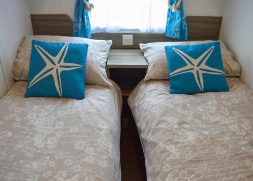 two beds sitting next to each other in a room at Anchor Park in Happisburgh
