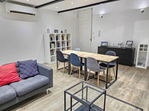 un salon avec un canapé, une table et des chaises dans l'établissement L'atelier de la Sainte - Vieux Port Marseille, à Marseille