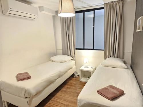 - 2 lits dans une petite chambre avec fenêtres dans l'établissement L'atelier de la Sainte - Vieux Port Marseille, à Marseille