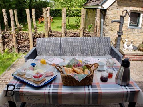 a picnic table with a basket of food on it at Bed & Brochje Burgum in Bergum