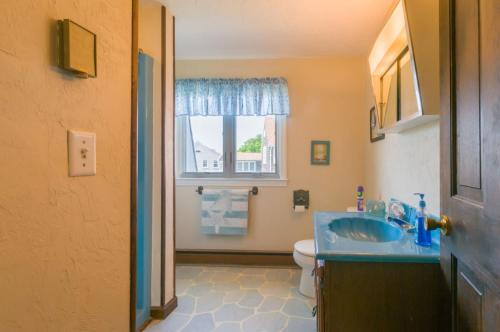 een badkamer met een wastafel, een toilet en een raam bij 5 Bryant Road Bourne Sunset Cottage in Buzzards Bay
