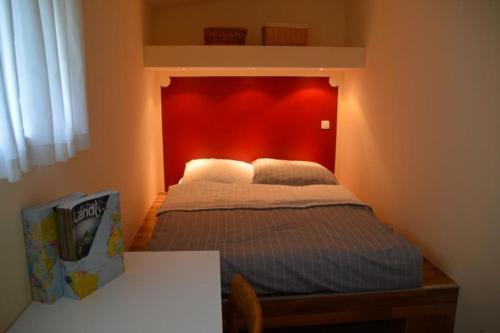 a bedroom with a bed with a red wall at Ferienwohnung am See in Soderstorf in Soderstorf