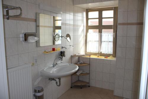 baño con lavabo, espejo y ventana en Stadtschloß Hecklingen***, en Hecklingen