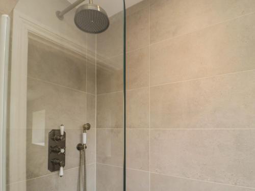 een douche met een glazen deur in de badkamer bij The Hollow in Hexham