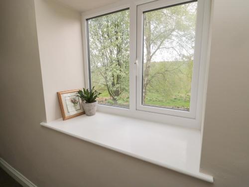 a window sill with a picture and a plant on it at The Hollow in Hexham