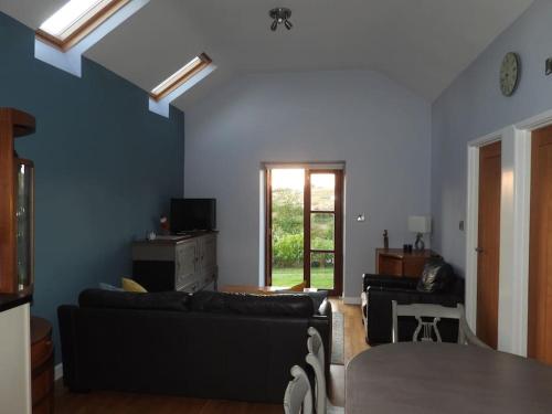sala de estar con sofá y mesa en Nature's Oasis: Pet-Friendly Snowdonia Cottage, en Trawsfynydd