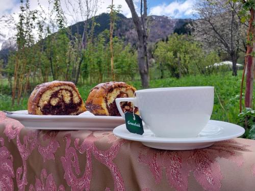 a cup of coffee and a plate of bread on a table at Guesthouse Leno in Tsaldashi