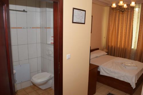 a small bathroom with a toilet and a shower at Hotel Tivoli in Tetovo