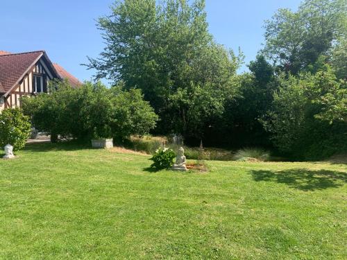 einen Hof mit grünem Gras und einem Haus und Bäumen in der Unterkunft Le Margouillat 
