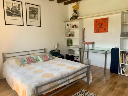 Schlafzimmer mit einem Bett und einem Glastisch in der Unterkunft Le Margouillat 