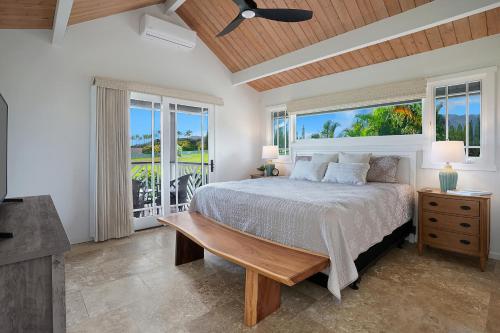 a bedroom with a bed and a large window at Kaiana Villa in Princeville