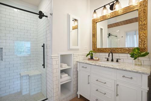 a white bathroom with a sink and a mirror at Kaiana Villa in Princeville