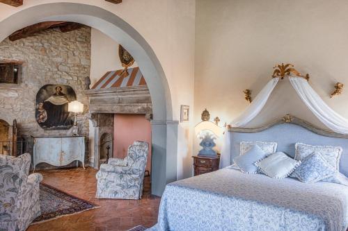 a bedroom with a blue bed and a fireplace at Relais & Ch&acirc;teaux Il Falconiere in Cortona
