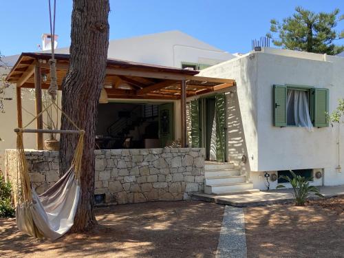 a house with a hammock in front of it at keronia house in Stalida
