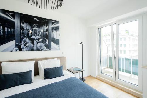 a bedroom with a bed and a large window at Hamilius Apartments City Center Luxembourg by Rentaroo in Luxembourg