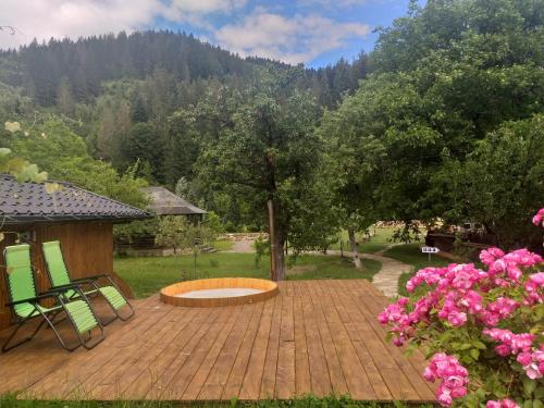 eine Terrasse mit einer Feuerstelle und rosa Blumen in der Unterkunft Pensiunea Agroturistica Cristal in Suceviţa