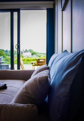 a couch with pillows in a room with windows at Saul Lodges in Saul