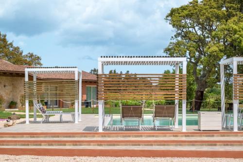 a pavilion with two chairs and a pool at La Vinia Bed&Wine Experience - Adults Only in Sassari