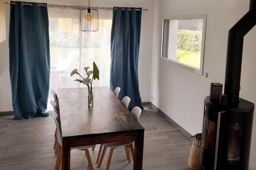 une salle à manger avec une table et des chaises et une fenêtre dans l'établissement Maison proche du Port de Dinan, à Lanvallay