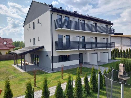 Casa blanca con balcones azules y patio en VILLA EDEN USTKA wypoczynek dla dorosłych en Ustka