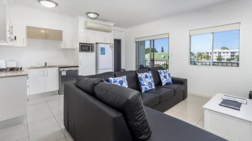 a living room with a couch and a kitchen at Stylish Unit With Water Views in Bellara