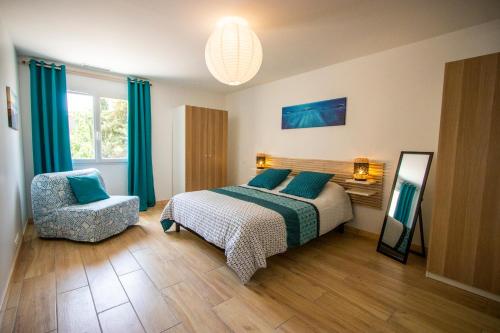 a bedroom with a bed and a chair at Gîte du Montagut in Thézan-des-Corbières