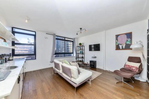 a kitchen and living room with a couch and chairs at Cosy 1BD APT in the Mother City in Cape Town