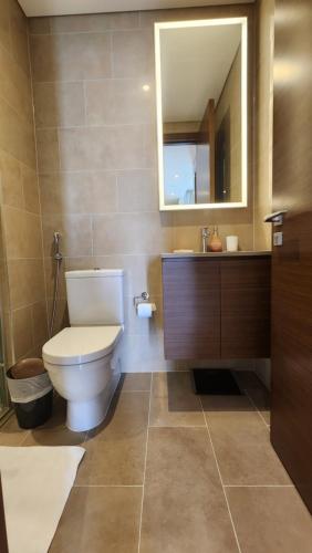 ein Badezimmer mit einem WC, einem Waschbecken und einem Spiegel in der Unterkunft STAY BY LATINEM Luxury 1BR Holiday Home CVR A2410 near Burj Khalifa in Dubai