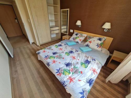 a bedroom with a bed with a floral bedspread at 10Q - Z6 Apartment 304 in Warsaw