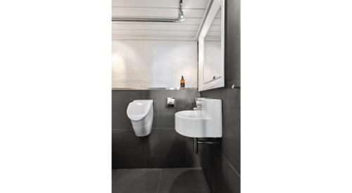 a bathroom with two toilets and a sink at Solsiden - in the center of Geilo in Geilo