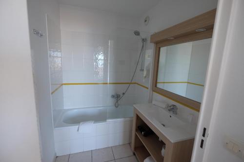 une salle de bain avec une baignoire, un lavabo et un miroir dans l'établissement Palais Des Dômes 718, à Nice
