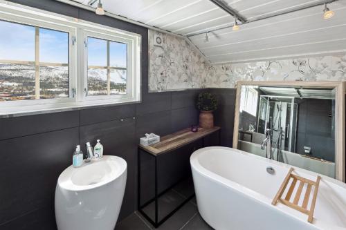 a bathroom with a tub and a sink at Solsiden - in the center of Geilo in Geilo
