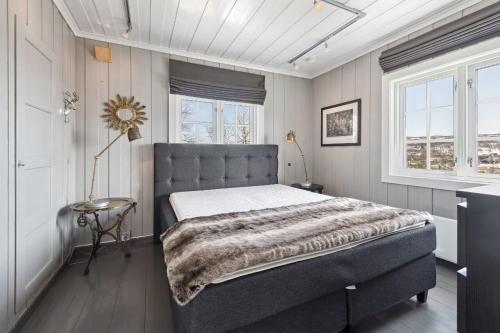 a bedroom with a large bed in a room with windows at Solsiden - in the center of Geilo in Geilo