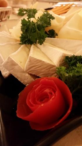 a plate with a red rose and different types of cheese at Hotel Villa Degli Angeli in Castel Gandolfo